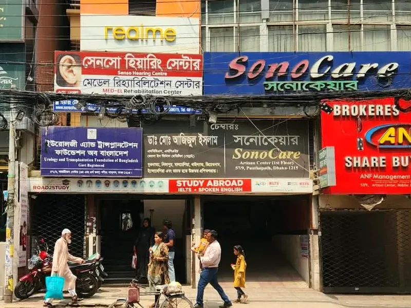 রাস্তার ওপার থেকে ভবনের সামনের সারি সারি সাইনবোর্ড, তার মধ্যে লাল রঙে “সেনসো হিয়ারিং সেন্টার”